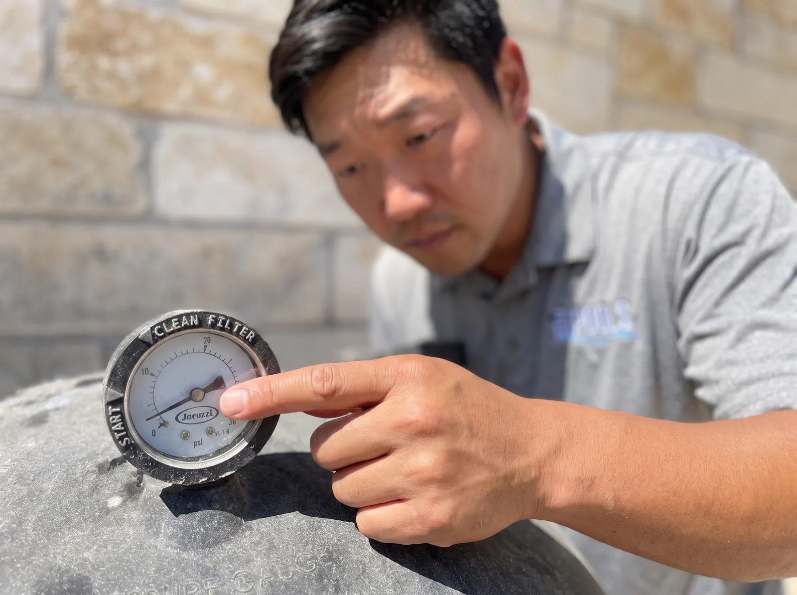 Max checking the filter pressure gauge on a pool equipment pad